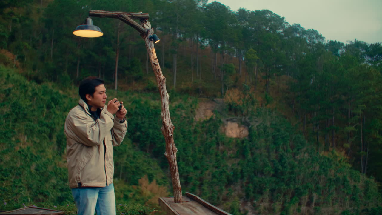 Man taking photo in a forest with mountain view