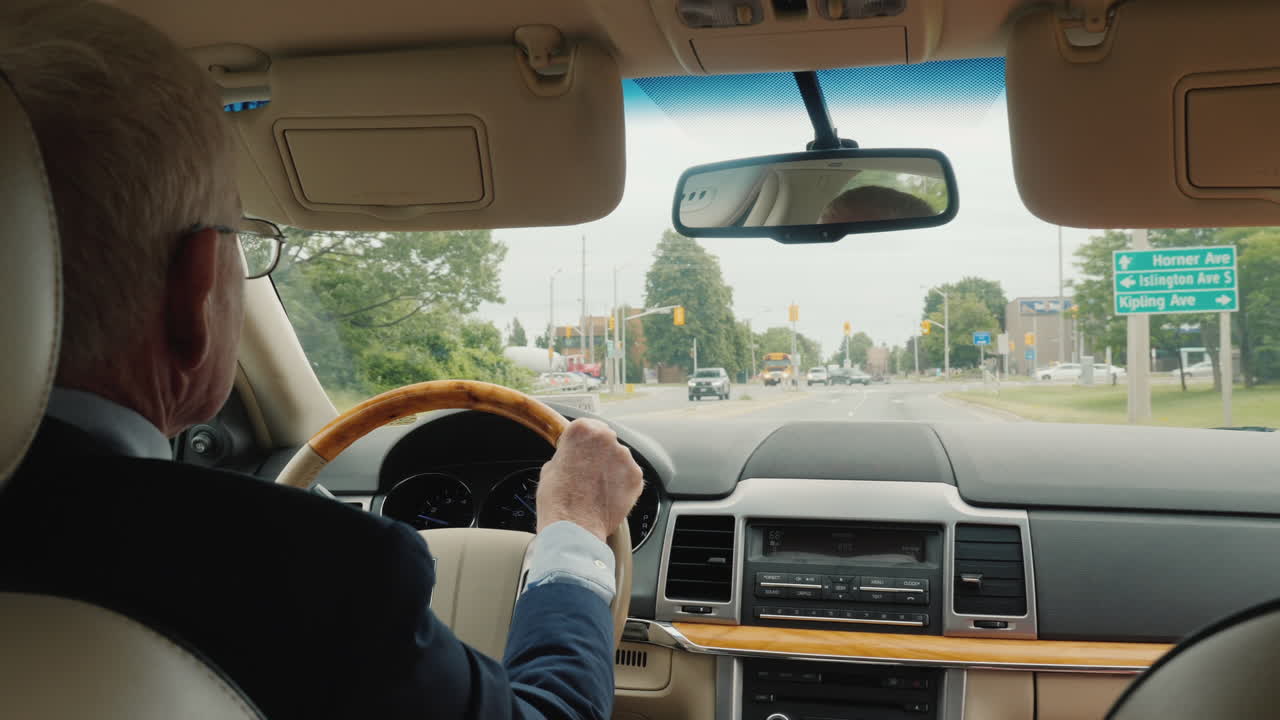 차를 운전하는 잘생긴 사업가가 캐나다 토론토의 거리를 달린다