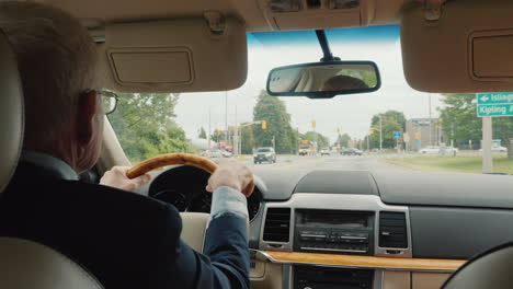 Un-Apuesto-Hombre-De-Negocios-Conduciendo-Un-Automóvil-Recorre-Las-Calles-De-Toronto-En-Canadá