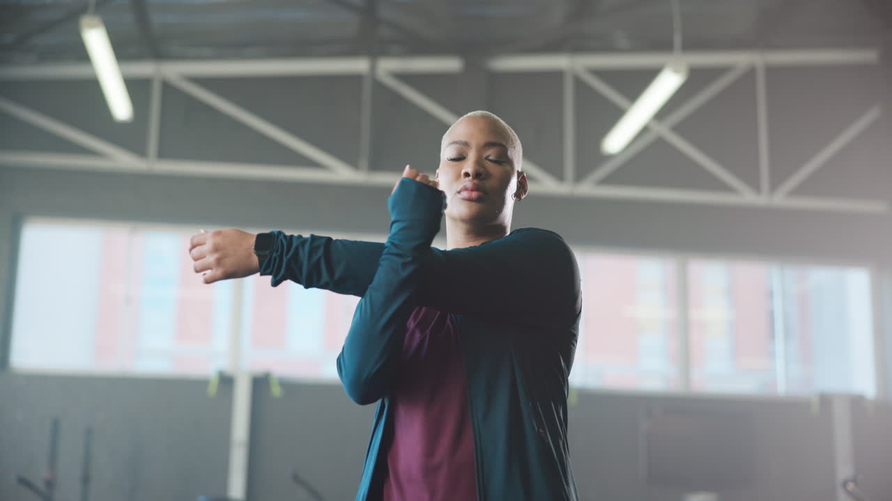 Woman stretching her arm in a gym