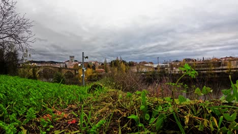 Zeitraffer-Der-Römischen-Brücke,-Des-Mino-Flusses-Und-Der-Straße,-Die-Nach-Ourense-Führt,-Während-Wolken-Am-Himmel-Rauschen