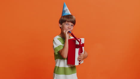 feliz emocionado chico afortunado usando sombrero de cumpleaños cono soplar pipa celebrando el éxito de la fiesta ganar victoria