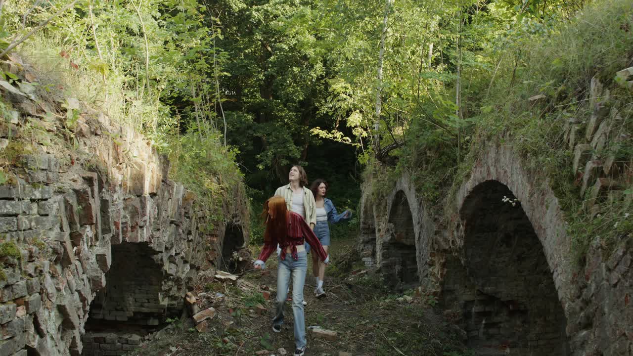 jóvenes explorando ruinas abandonadas en un bosque