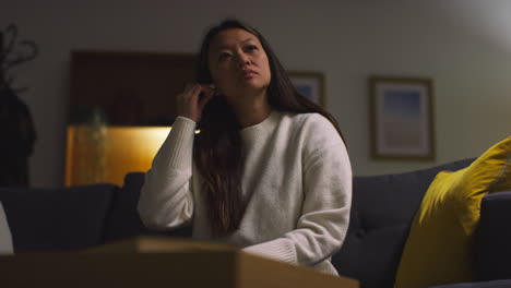 woman sitting on a couch looking at her phone