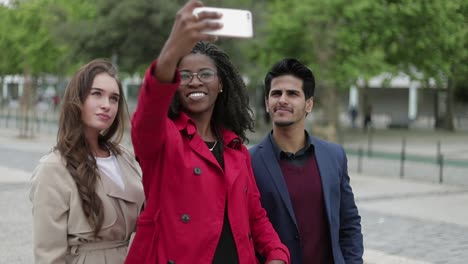 Women-and-man-making-selfie-outside,-posing,-smiling