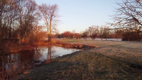 golf course ponds at calm, foggy sunset in fall in america