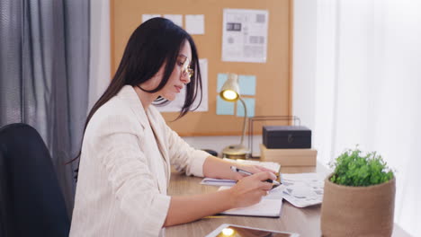 Pensive-Focused-Woman-Uses-Calculator-at-Work-in-Office