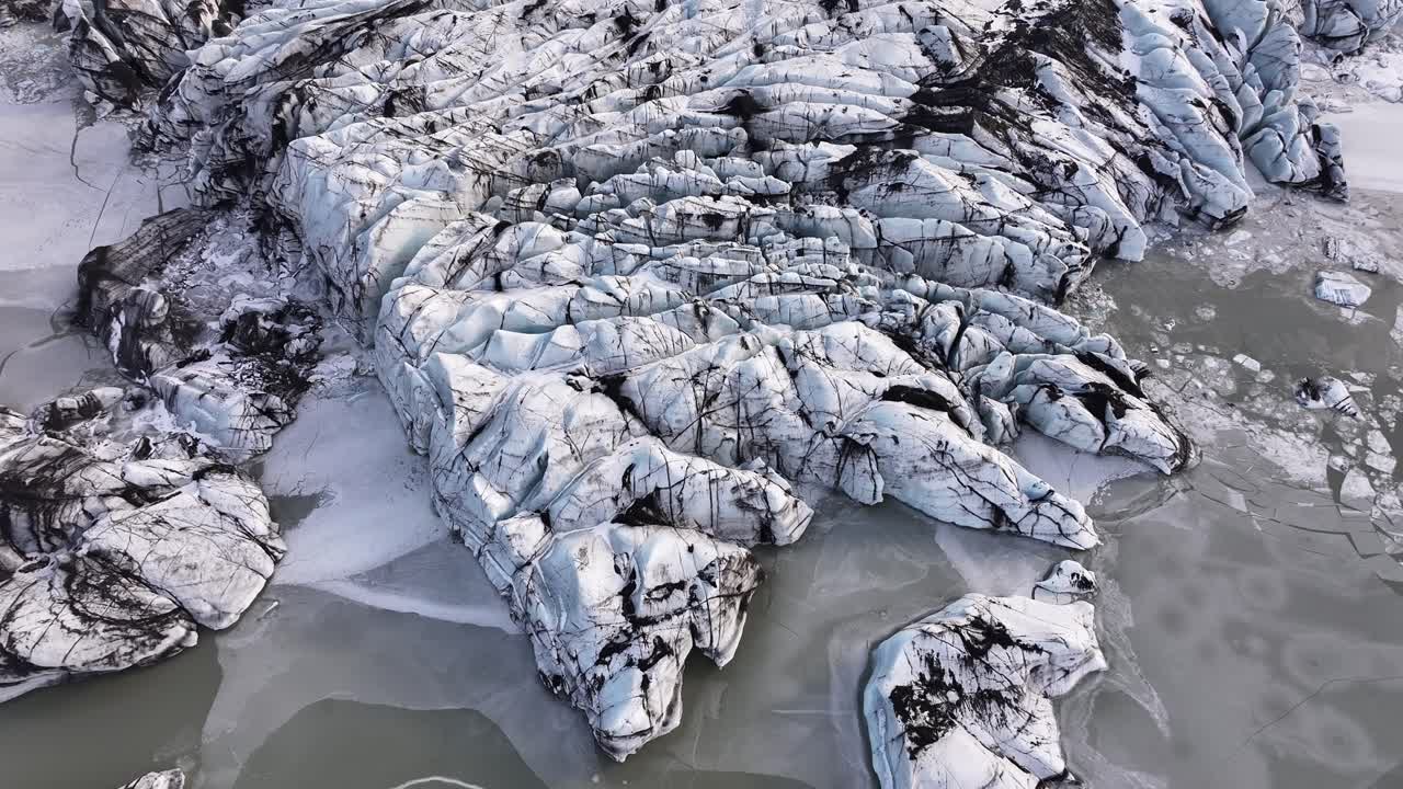 Drone ascending and revealing dramatic ice formations at Sólheimajökull, Mýrdalsjökull Glacier, Iceland.
