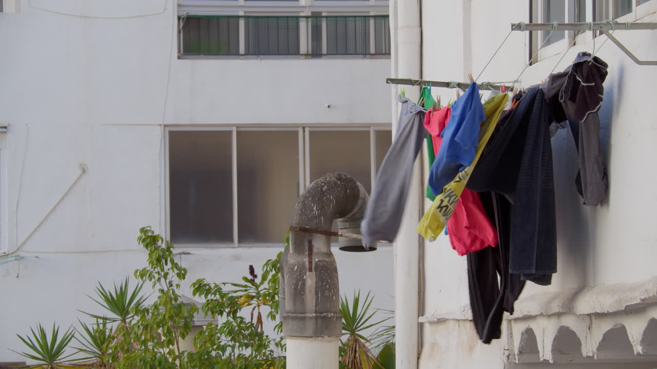 Laundry Drying in the Wind Against White Wall