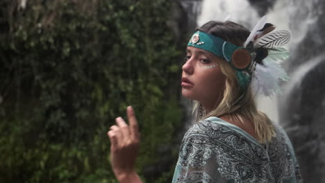 woman in a boho headdress near a waterfall