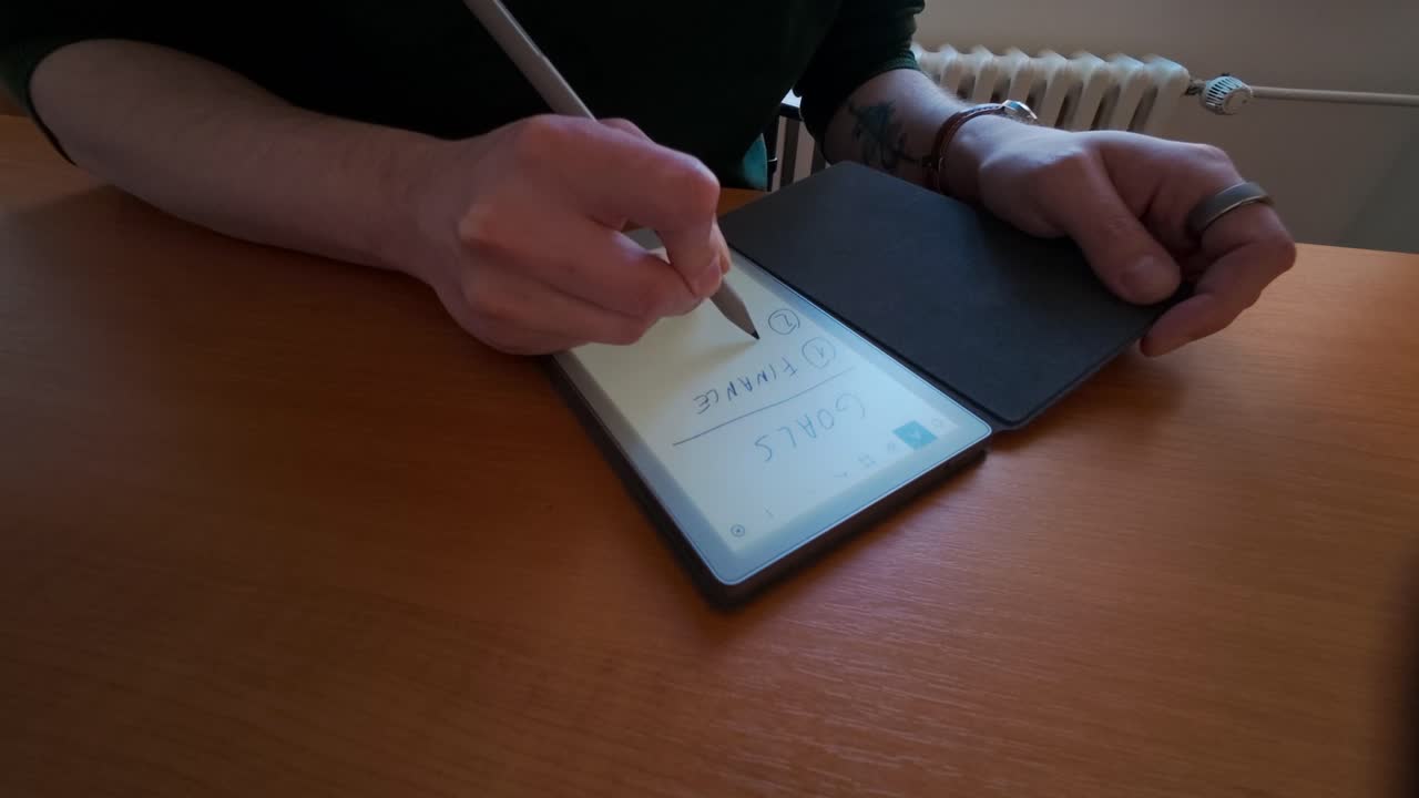 A man writes a list of tasks in a digital notebook. Organizing goals and prioritizing tasks