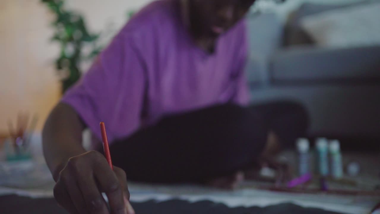 Young African woman drawing picture at home