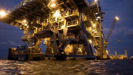 brightly lit offshore oil rig at night
