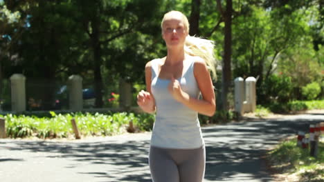 a woman jogs down the street as she looks to the side