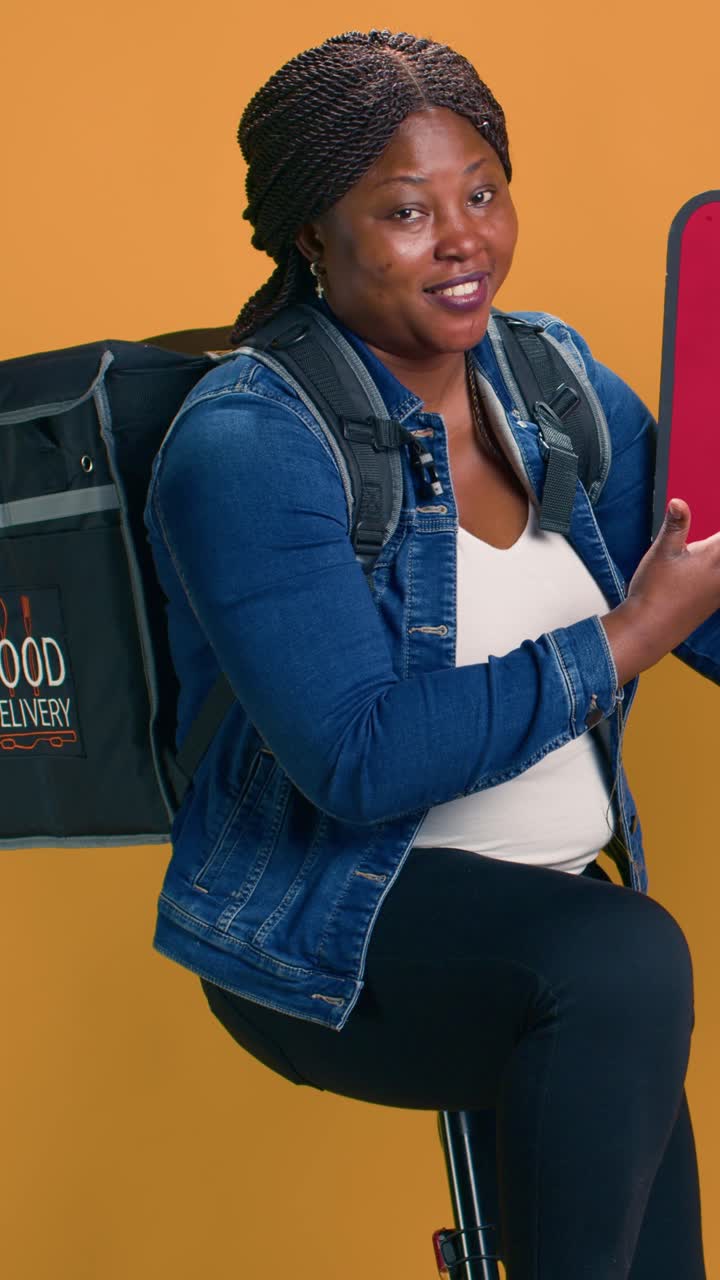 Woman with food delivery bag gives thumbs up