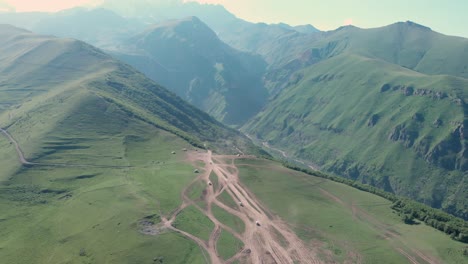 vista aérea desde drones de autos conduciendo por caminos de montaña en gergeti, georgia