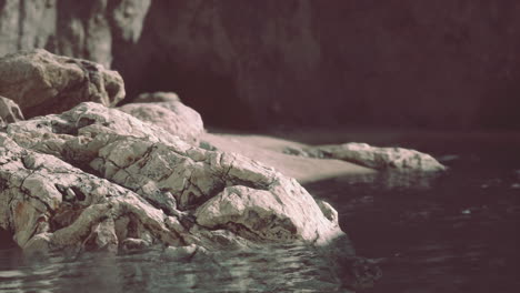 rocky shoreline at dusk with calm water and reflective surface