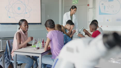 in school, students conducting science experiments with teacher in classroom