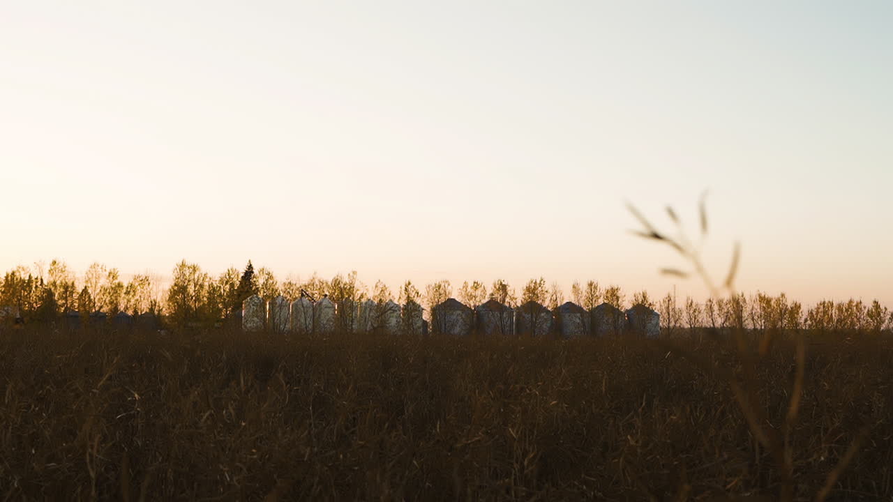 Sunset Over Agricultural Land With Large Silo Containers. Static Shot
