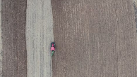 a red tractor plowing the field