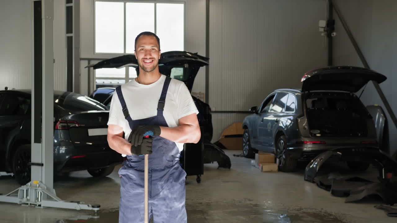 un mecánico de automóviles sonriente en el garaje