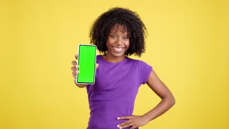 african american woman presenting green screen smartphone