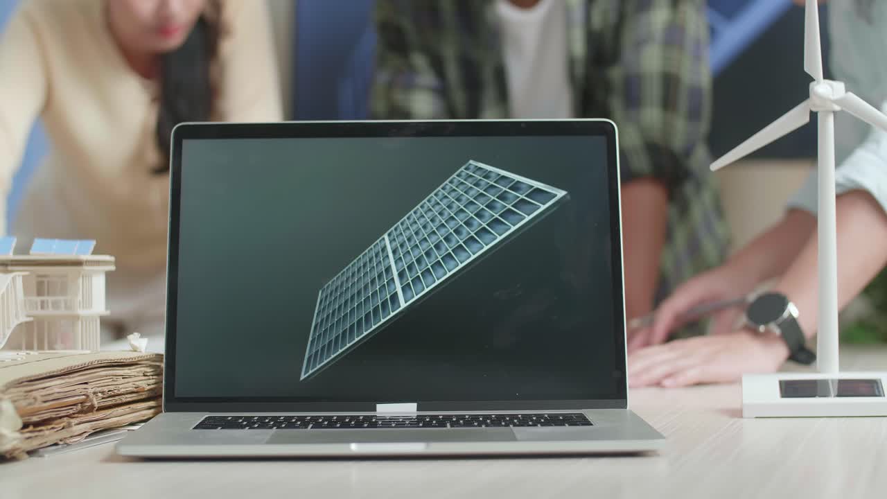 테이블 위의 노트북의 클로즈업은 엔지니어 그룹이 사무실에서 블루프린트 작업에 대해 논의하는 동안 태양 셀을 보여줍니다.