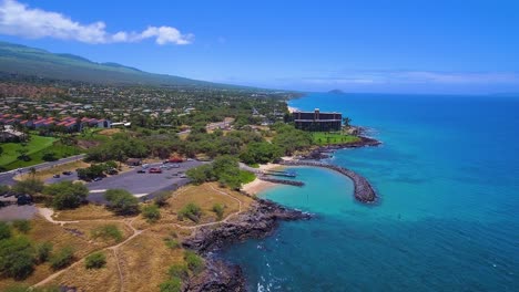 Flying-low-along-the-coast-of-Kihei,-Hawaii-on-a-sunny-day,-truck-camera-move-to-the-right