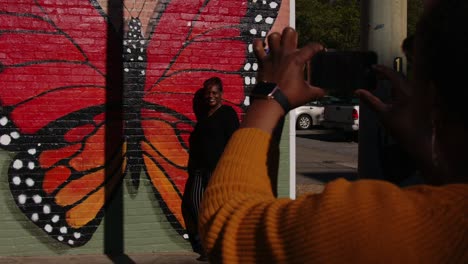 americus first friday art event sumter county georgia young woman being photographed next to large wall mural of butterfly