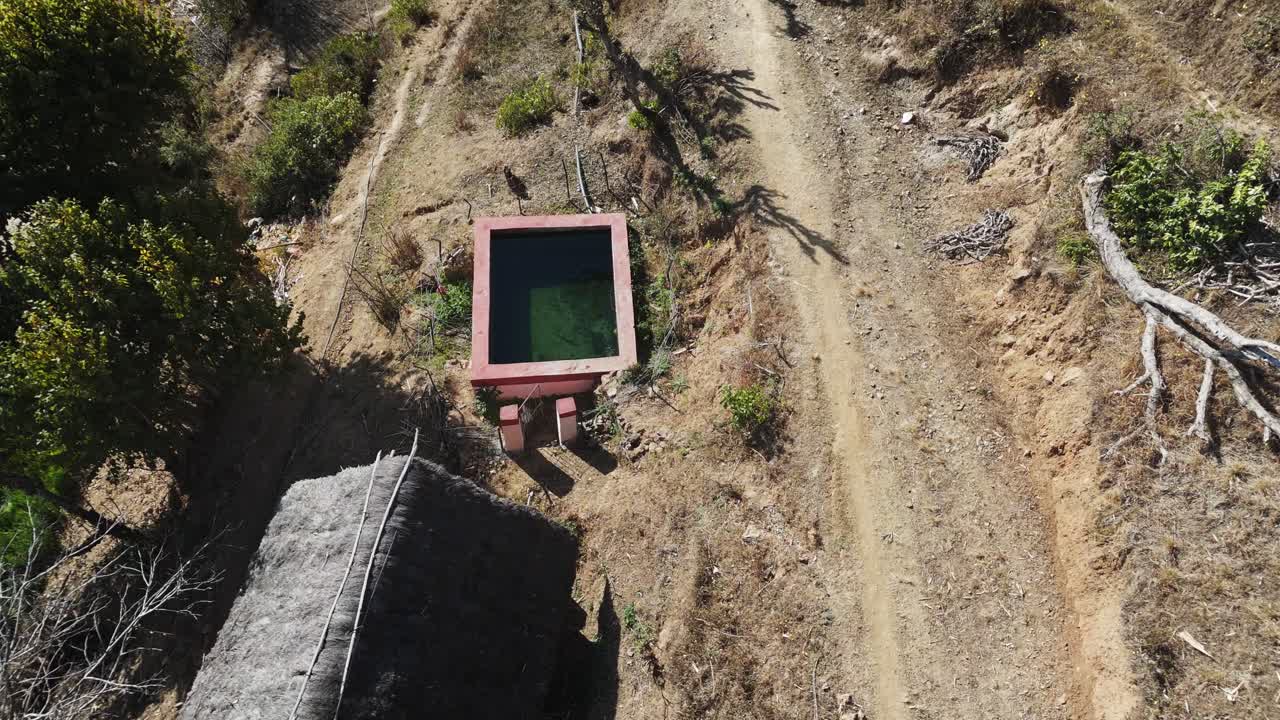 Riprese di un villaggio remoto che utilizza un sistema solare per pompare acqua in stagni di irrigazione. Evidenzia energia rinnovabile, supporto all'agricoltura e sviluppo rurale sostenibile