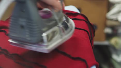 a woman ironing a red dress