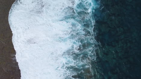 bird’s eye view of stormy waves crashing on coastline of loyalty islands, new caledonia