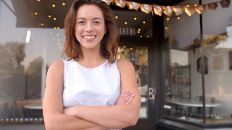 Propietaria-De-Un-Negocio-Femenino-Afuera-De-Una-Cafetería-Caminando-Hacia-El-Plano-Focal