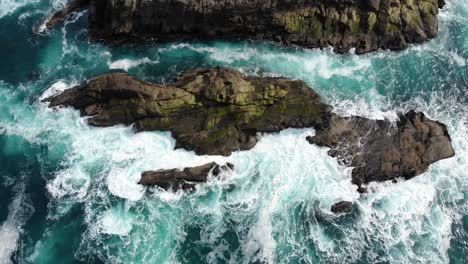 Drone-watches-from-above-as-waves-crash-into-rocks-on-the-coastline