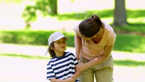 Mother-talking-to-her-young-son-playing-football