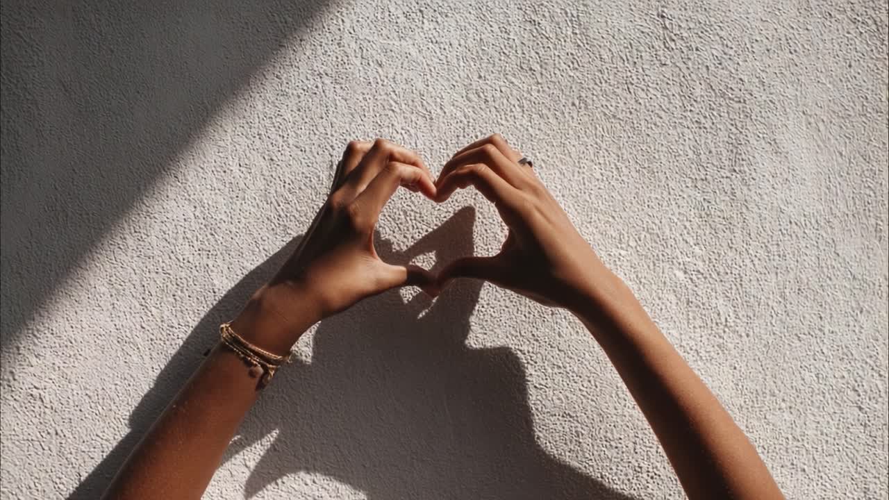 Capturing the Essence of Love: A Visual Representation of Heartfelt Emotions through Hands Forming a Heart Shape Against a Textured Background