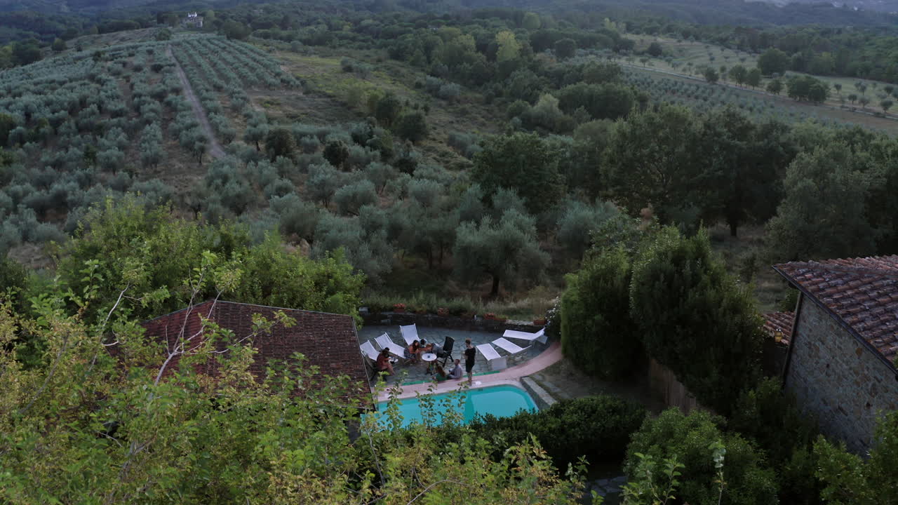 toma de drones de un pequeño resort en florencia, drones volando sobre el entorno natural, revelando una hermosa piscina y gente de vacaciones