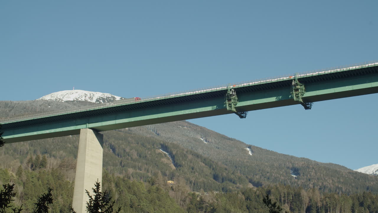 Modern high-altitude bridge near Brenner Pass with car driving by.