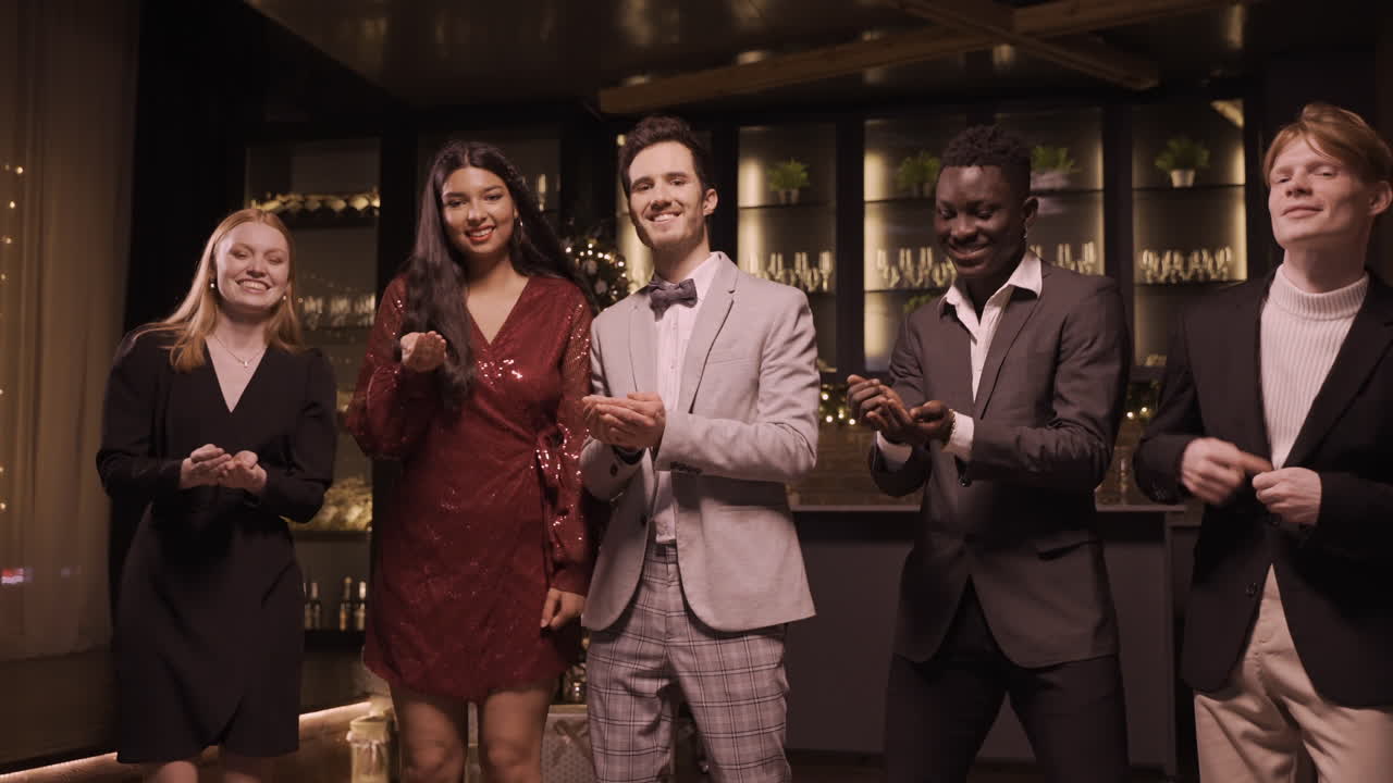 신년 파티에서 춤을 추면서 우아한 옷을 입은 친구들이 색종이 조각을 날리고 던진다