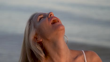 Retrato-De-Una-Hermosa-Mujer-Rubia-Madura-En-La-Playa-Al-Atardecer-Coqueteando-Con-La-Cámara