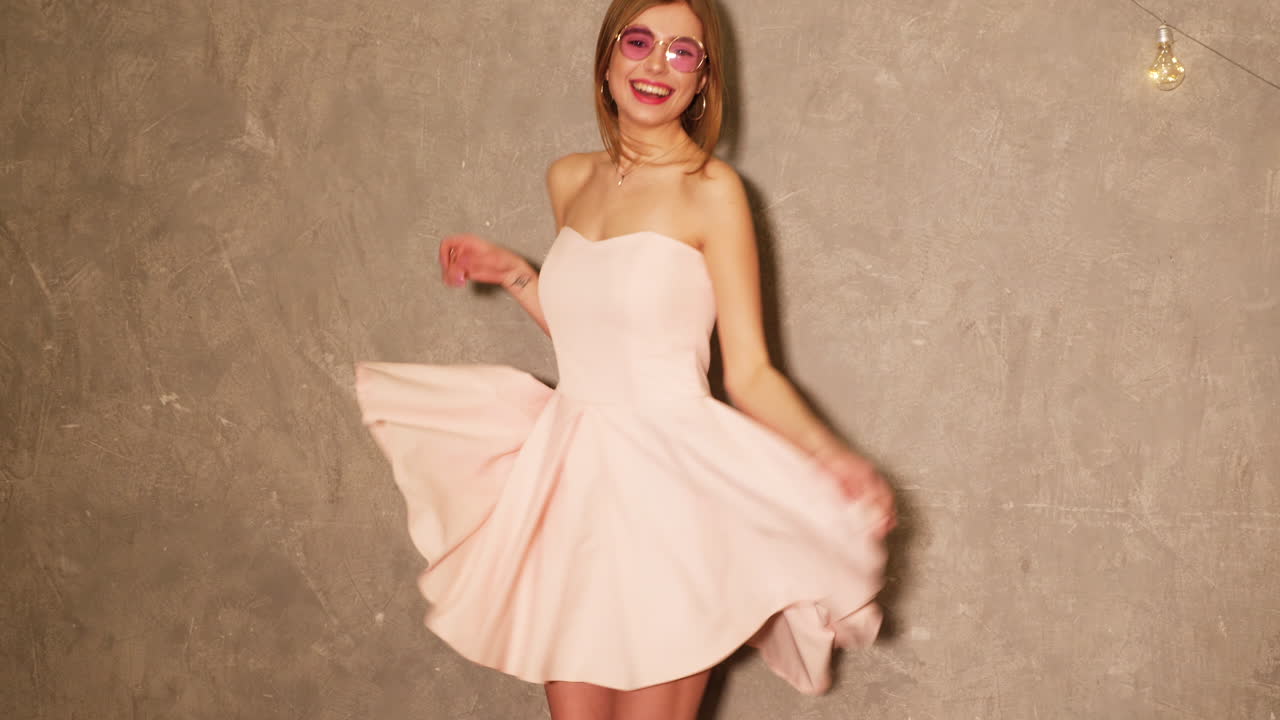 분홍색 드레스와 선글라스를 입은 웃는 여자