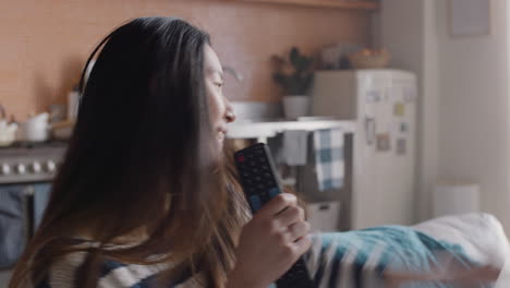 mujer asiática feliz cantando en casa divirtiéndose celebrando un estilo de vida exitoso bailando disfrutando de la música karaoke entretenimiento el fin de semana