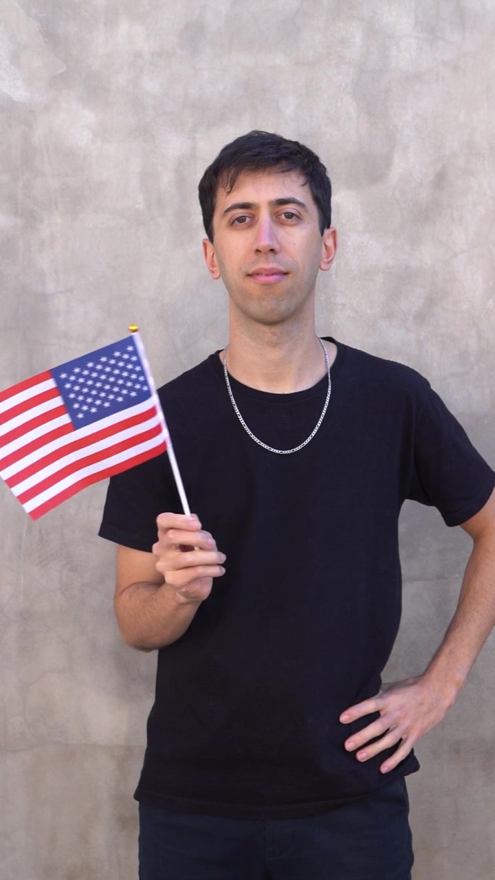 Uomo che sventola la bandiera americana al rallentatore. Concetto di bandiera nazionale degli Stati Uniti. Inquadratura verticale