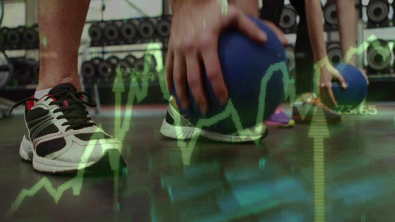 On cue athlete balancing and stepping in gym, partner picking med ball, green graph overlaying feet