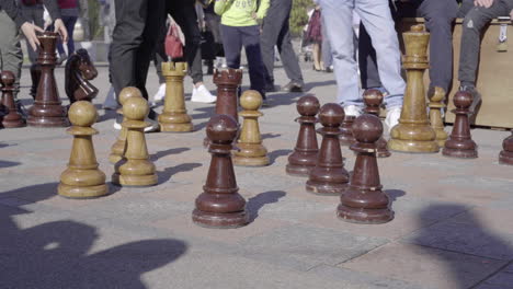 People-playing-and-watching-giant-chess-strategy-game-in-public-park-of-Lugano-4k