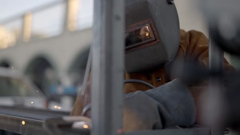 welder welding metal construction in workshop sparks shield mask slowmo