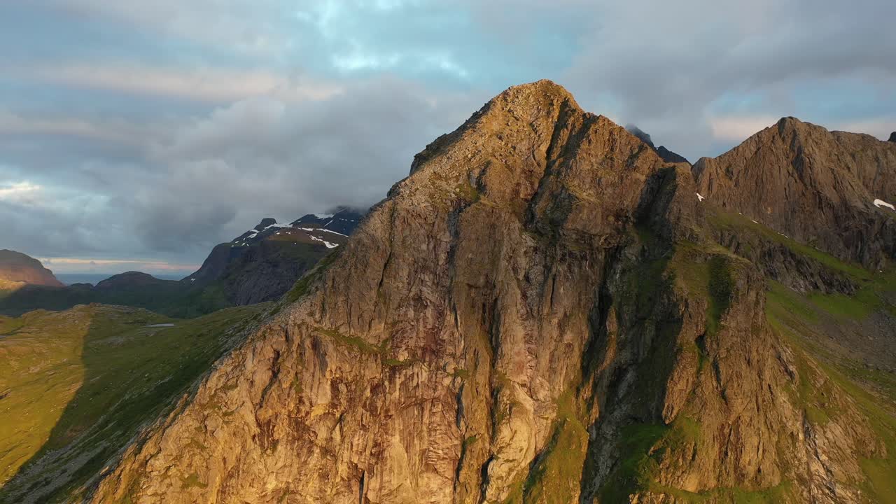 Sole di mezzanotte che illumina il versante della montagna a Lofoten, Norvegia