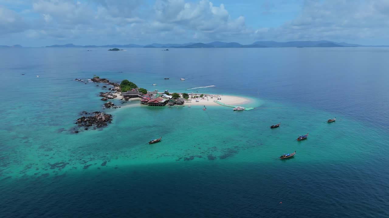 Drone orbits and descends right over Khai Island sandbar with longtail boats on the Andaman Sea