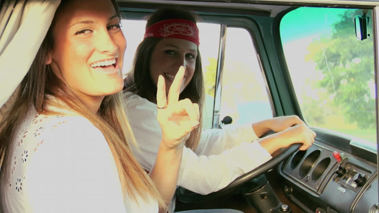 una mujer da un signo de paz y se ríe