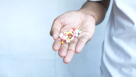 handful of colorful pills in hand